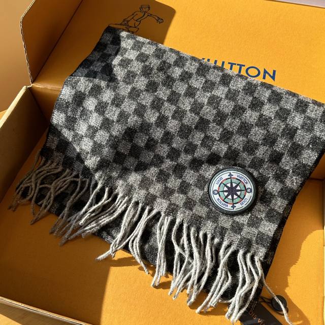 Damier Graphite 12 Letters Petit Damier 围巾取材绵羊毛针织，以铝箔印制工艺呈现全新路易威登标识，令品牌挚爱的 Petit