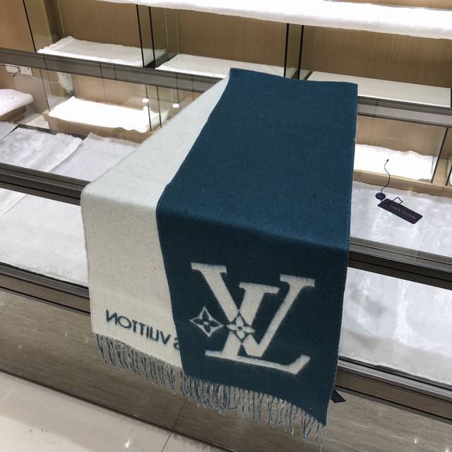 Lv 双重图形围巾 205*26Cm 100%羊毛 Lv Graphic Dual 围巾采用初剪羊毛图形双重混纺裁出宽幅尺寸，以鲜明双色设计烘托 Lv 字母，翻